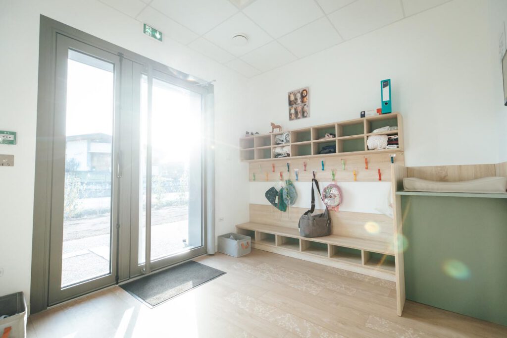 Salle d'accueil crèche avec banc et casiers